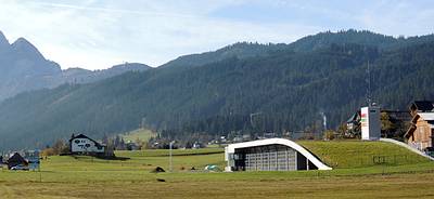 das wellenf�rmige Geb�ude mit dem begr�nten Dach f�gt sich in die bestehende Landschaft ein
