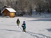 Die Kinder stapfen durch den Schnee.