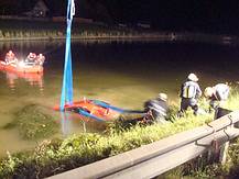 der versunkene rote Toyota wird von der Feuerwehr gesichert