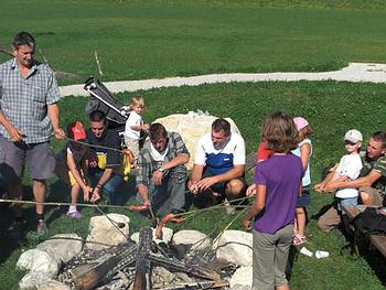 V�ter mit Kindern beim W�rstelbraten beim Spielplatz in Gosau